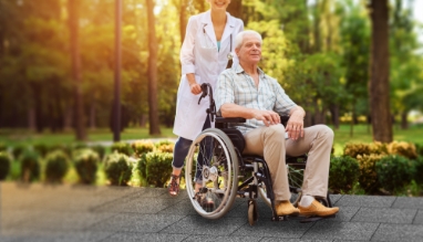 doctor-with-old-man-wheelchair-walking-sunny-park_2_2