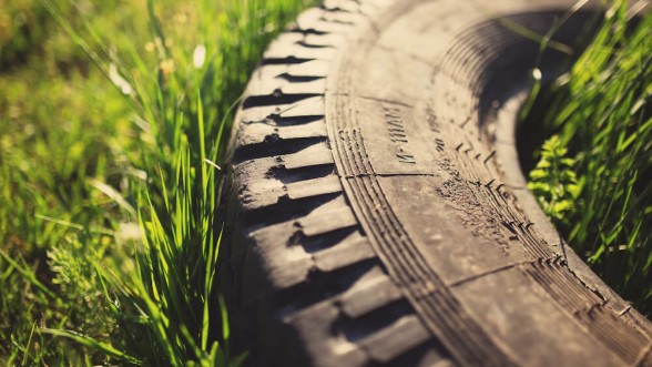 old-tire-grass-tinted-photo